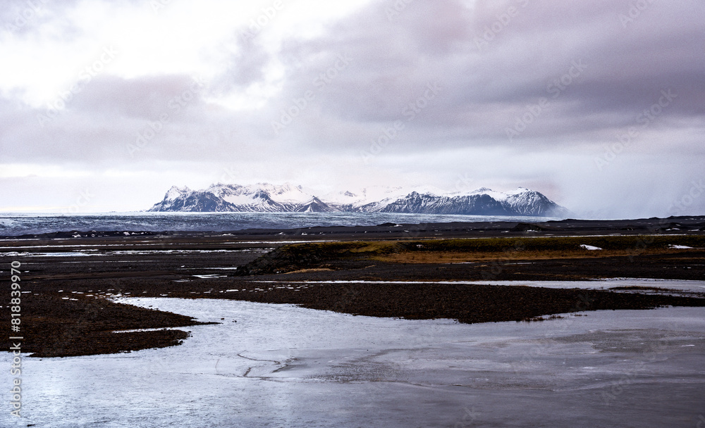 a river with water and rocks and snowy mountains in the distance a river with water and rocks and snowy mountains in the distance