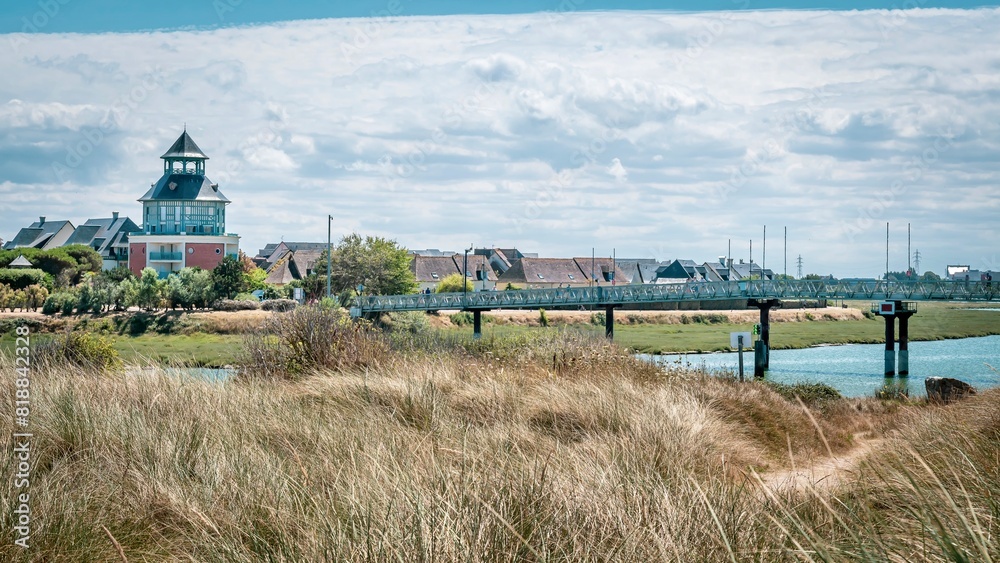 Picturesque river spans with a charming bridge amidst towering buildings and a serene beach Picturesque river spans with a charming bridge amidst towering buildings and a serene beach