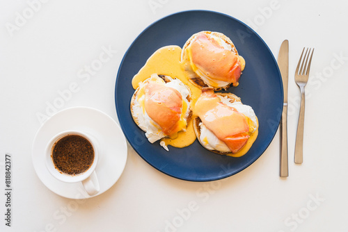 Toast with salmon, poached egg, cream cheese and Goland sauce. Bruschetta with poached egg and salmon. Open sandwich and cup of coffee. Delicious and healthy breakfast concept