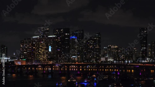 Wallpaper Mural Distant panoramic view of Miami downtown, outline of marina in foreground, illuminated skyscrapers on background against dark cloudy sky. Slow motion camera moving along MacArthur Causeway Bridge . Torontodigital.ca