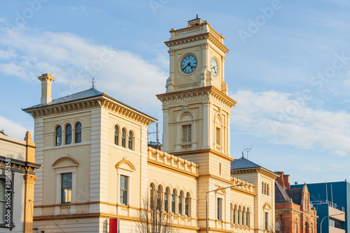 Streetscape featuring a tall clock tower and grand historic buildings in late afternoon light photo