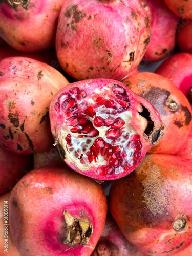 an open pomegranate on a pile of pomegranates photo