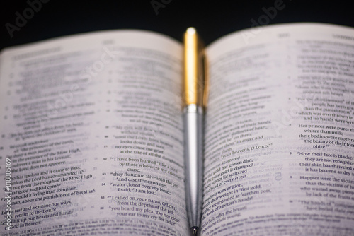 Top shot of an open Christian Bible with a pen in the middle depicting Bible study and fellowship photo