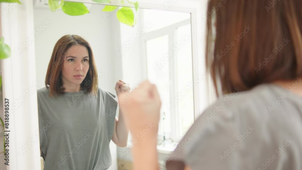 Unwell worried angry anxious female looking in mirror at home and screaming Unwell worried angry anxious female looking in mirror at home and screaming