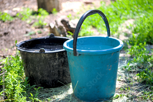 Black and blue plastic bucket with water
