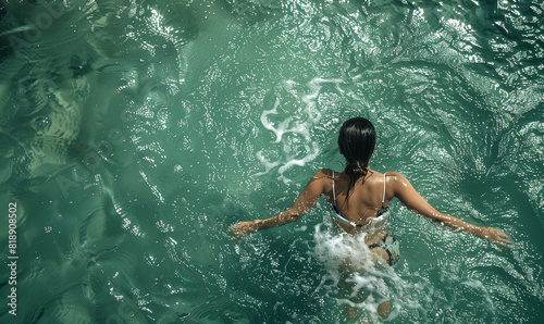 A woman floating on the sea waves, closes her eyes and breathes fresh air, enjoying the peace and quiet of the world around her.