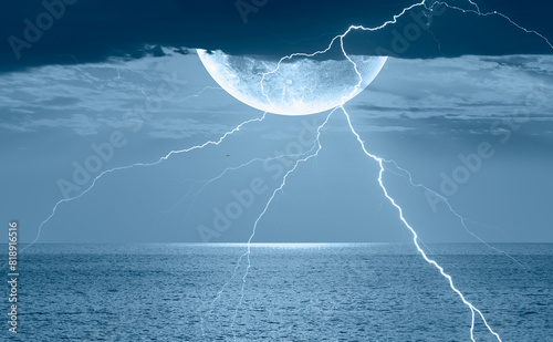 Night sky with full moon and lightning in the clouds on the fore ground calm  sea wave  © muratart
