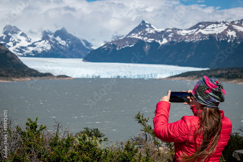 Mujer turista tomando fotografías al Glaciar Perito Moreno desde un mirador del Parque Nacional