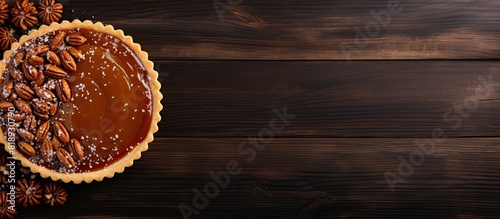Top view of a delicious nut and caramel tart on a wooden background with ample copy space for additional visual elements