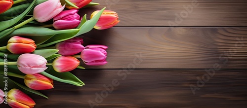 A vibrant display of tulips positioned on a wooden table creating an appealing copy space image