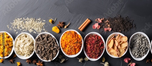 A flat lay arrangement of various types of dried teas placed on a gray table providing ample space for adding text