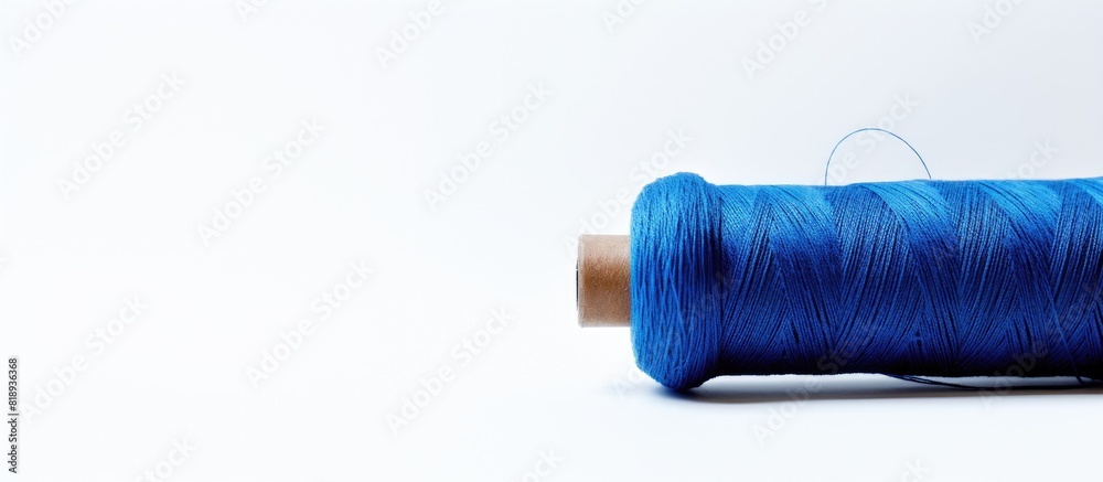 A view from above showing a blue wool thread against a white background with ample space for text or other images A view from above showing a blue wool thread against a white background with ample space for text or other images