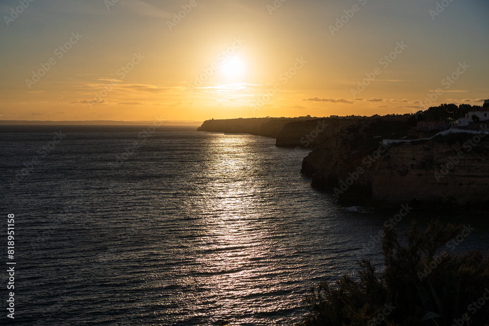 Algar Seco in Carvoeiro. Beautiful Golden Sandstone Rock Formation in Algarve with Atlantic Ocean in the Distance. Rocks, rocky shore, yellow rocks, coquina, beautiful coastline. Sunset