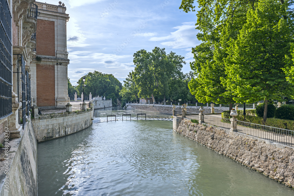 A water channel through stone walls passing through a monumental park in Aranjuez, Spain