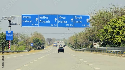 25 Feb 2024- Moving vehicles under Distance to city board on Yamuna Expressway.  photo