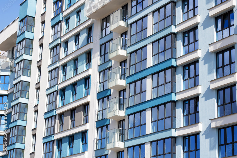 Urban design tower block with blue facade, numerous windows, and balconies
