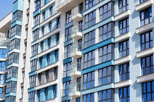 Urban design tower block with blue facade, numerous windows, and balconies