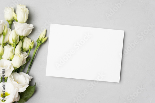 Blank wedding invitation or greeting card mockup with white eustoma flowers