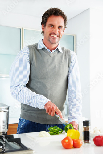 Portrait  happy man and cutting vegetables for cooking healthy diet  food or nutrition in home kitchen. Smile  knife and chopping board for vegan  lunch and organic meal prep for salad ingredients