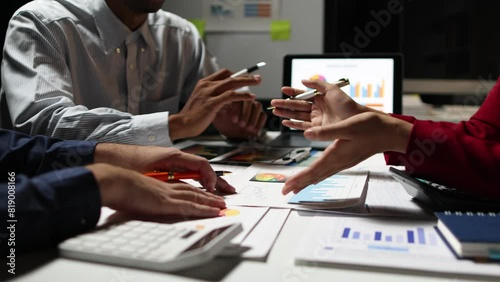 Businessman work overtime and meet with co-workers to discuss financial report analysis and market share situation to plan strategies. Discussion financial chart analysis to plan profit maximization. photo