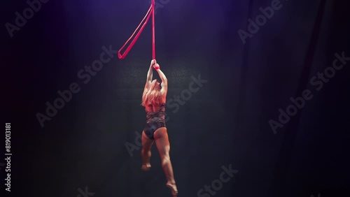 Circus artist girl aerial straps.