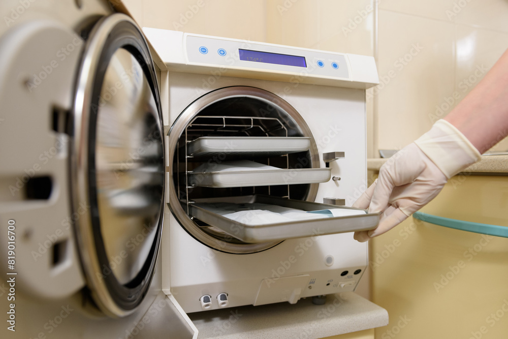 Sterilization of dental and surgical medical instruments. A dental assistant places medical steel dental equipment in bags for sterilization in an autoclave. Bacterial purification and disinfection. Sterilization of dental and surgical medical instruments. A dental assistant places medical steel dental equipment in bags for sterilization in an autoclave. Bacterial purification and disinfection.