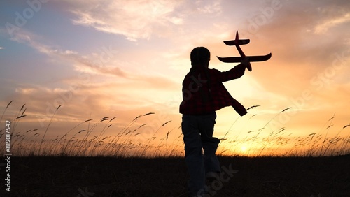 child kid girl with toy pilot runs into sunset dream flying flight, child with toy airplane, sunset playtime, running through field, kid's adventure, outdoor childhood activity, toy glider in nature