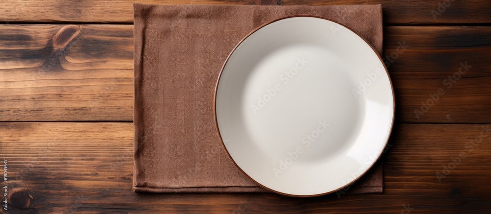 Empty plate with napkin on brown wooden table. copy space available Empty plate with napkin on brown wooden table. copy space available