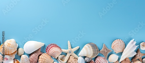 Copy space image of a summer themed flat lay featuring seashells on a serene blue background evoking the spirit of vacation and creativity