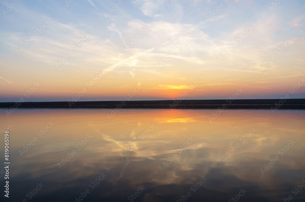 Obraz premium Reflection of the sunset in the water. Beautiful sunset over the sea. Colored sky at sunset.