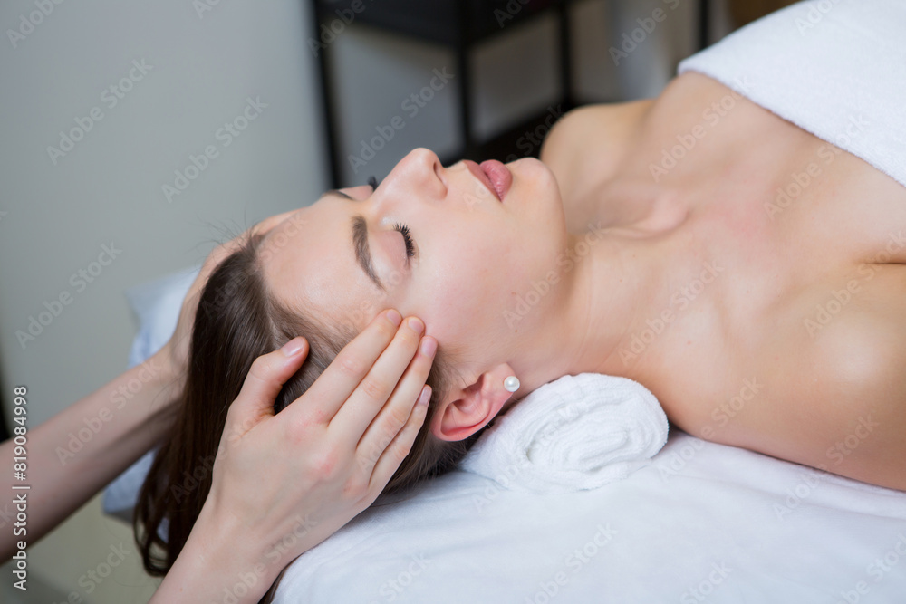 Beautiful young woman getting facial massage in spa salon. Beauty treatment concept. Beautiful young woman getting facial massage in spa salon. Beauty treatment concept.