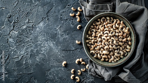 Bowl of black-eyed peas on dark textured surface with cloth photo