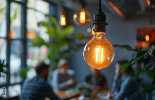 Group of People Sitting at Table Under Hanging Light Bulb