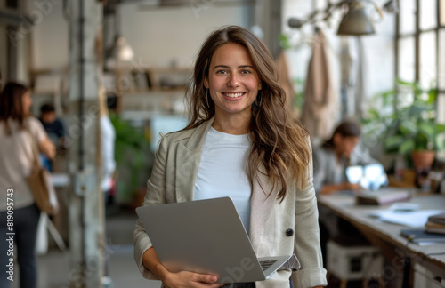 Smiling Woman Holding Laptop in Office
