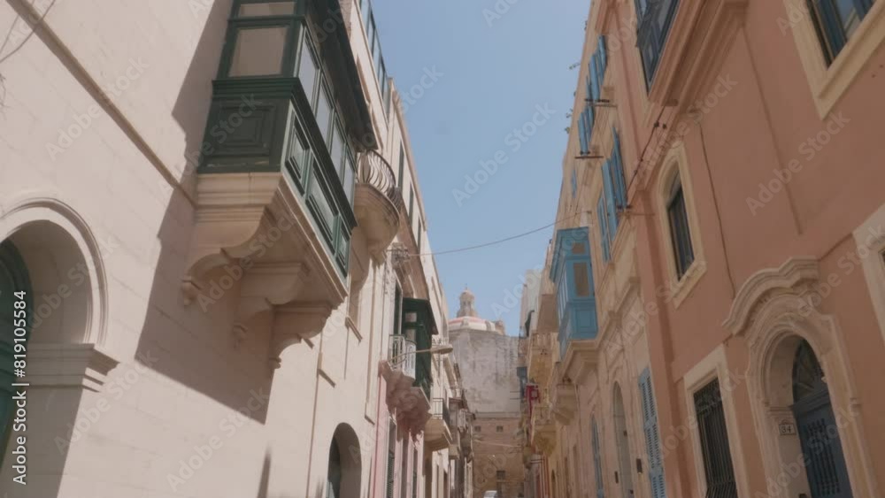 A long walking shot along a street, showing the beautiful traditional colorful Maltese balconies, on a sunny day in Senglea, Malta A long walking shot along a street, showing the beautiful traditional colorful Maltese balconies, on a sunny day in Senglea, Malta