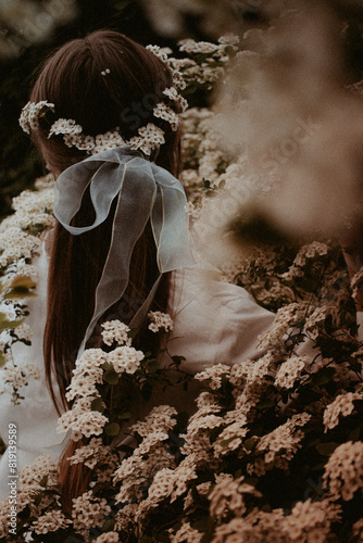 Girl among white tiny flowers