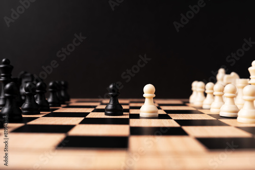 White pawn chess face off with black pawn chess black background