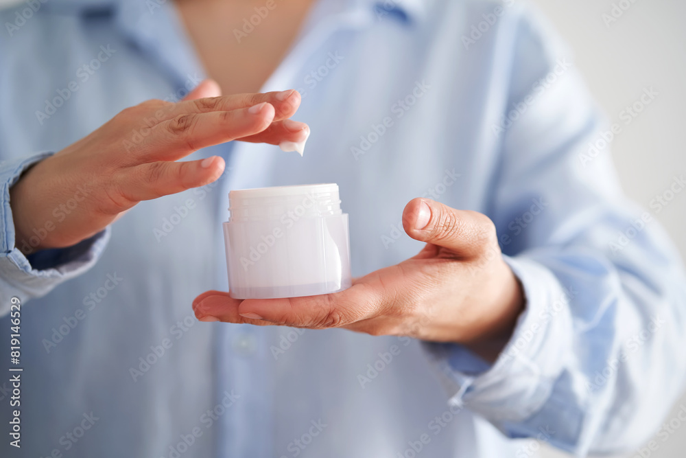 Hands in a blue shirt hold a jar of cream. Hands in a blue shirt hold a jar of cream.