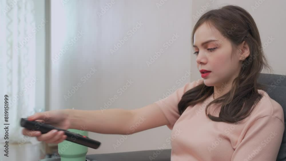woman wearing casual clothes sits and watches TV in the living room. woman wearing casual clothes sits and watches TV in the living room.