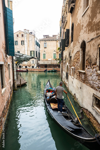 Foto A Gondolier in the city of Venice, Italy maneuvering his gondola in a canal