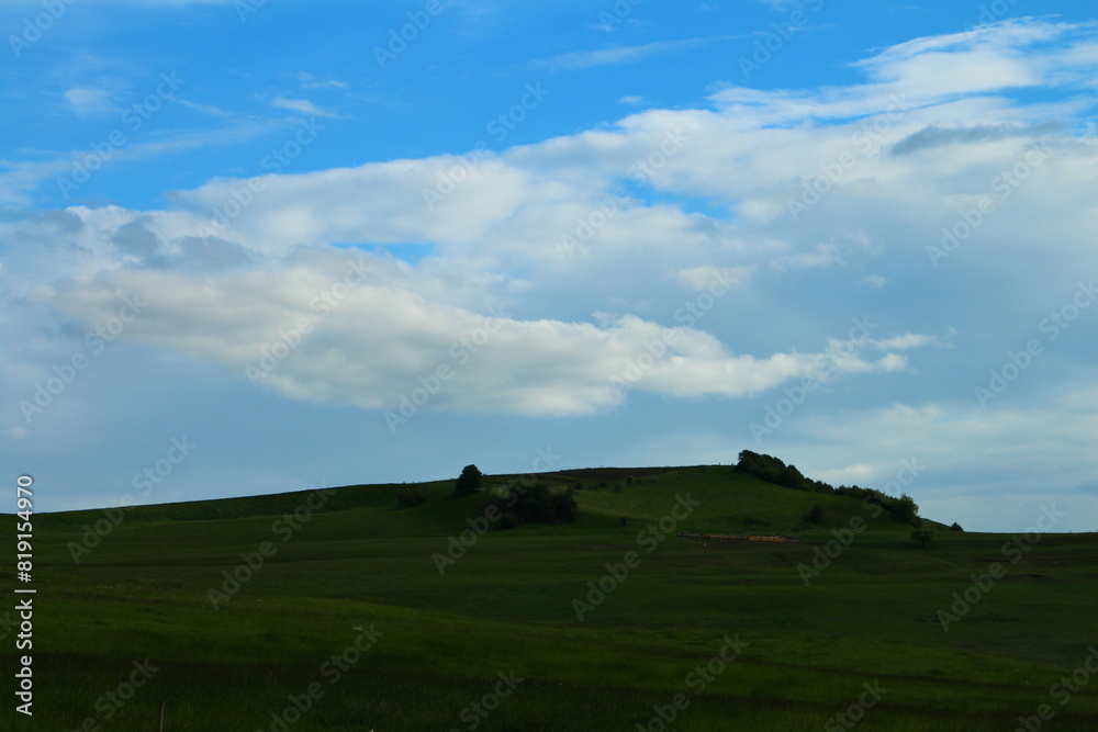 A grassy field with a cloudy sky A grassy field with a cloudy sky
