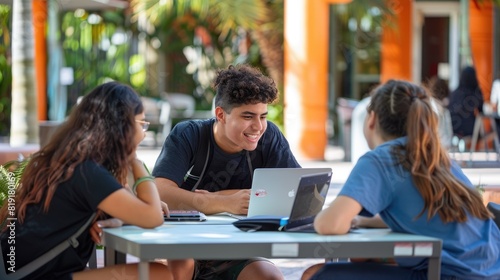 Three young people sitting around a table outside, talking and laughing.