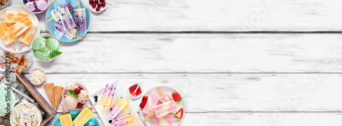 Cool summer food corner border. Assortment of refreshing ice cream, popsicle and frozen treats. Top down view on a white wood banner background.