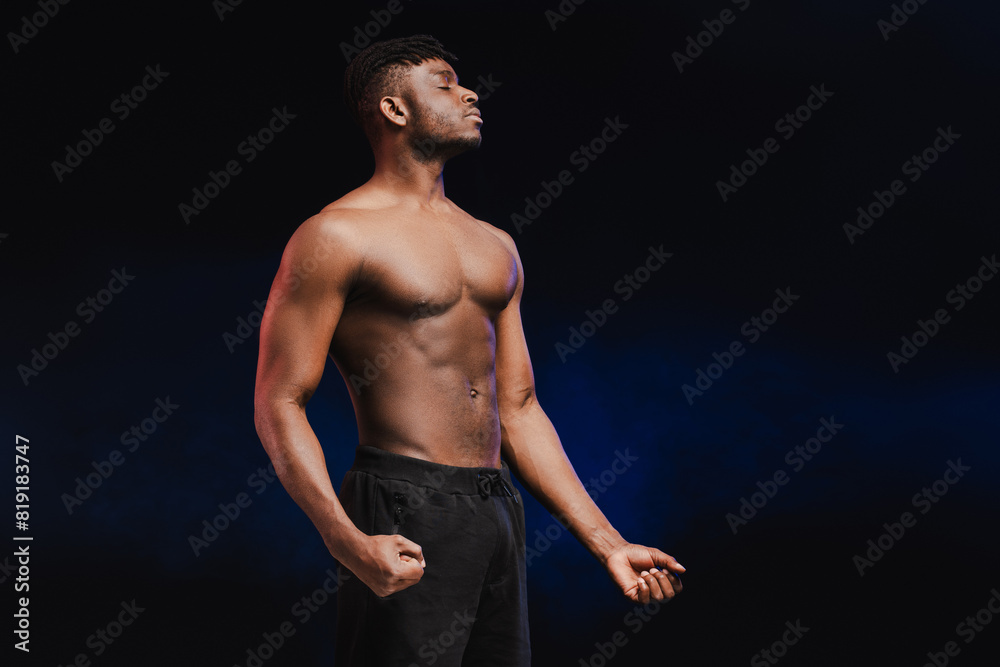 Naklejka premium Handsome serious African American male bodybuilder with naked pumped torso with closed eyes