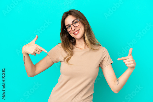 Young caucasian woman isolated on blue background proud and self-satisfied
