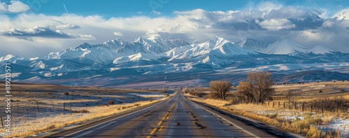 empty highway into beautiful snow capped rocky mountains. photo