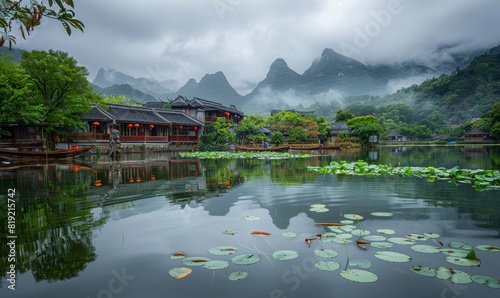 water village with house above the river. lotus plants on the water surface. beautiful cliffs in the background.