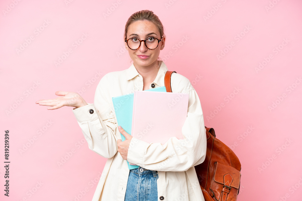 Young student caucasian woman isolated on pink background having doubts while raising hands Young student caucasian woman isolated on pink background having doubts while raising hands