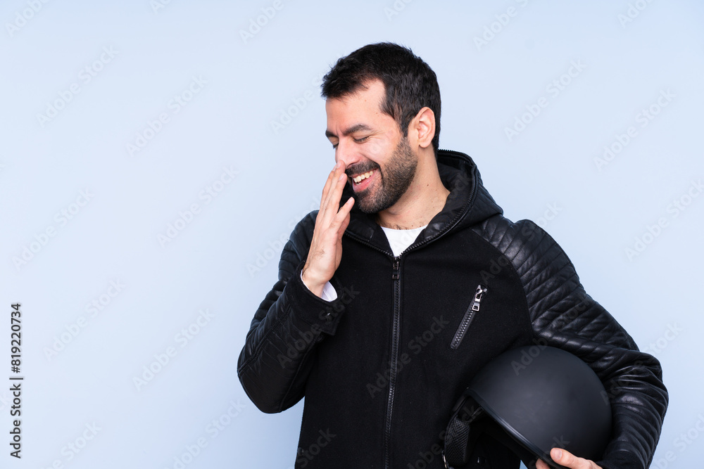 Man with a motorcycle helmet over isolated background smiling a lot Man with a motorcycle helmet over isolated background smiling a lot