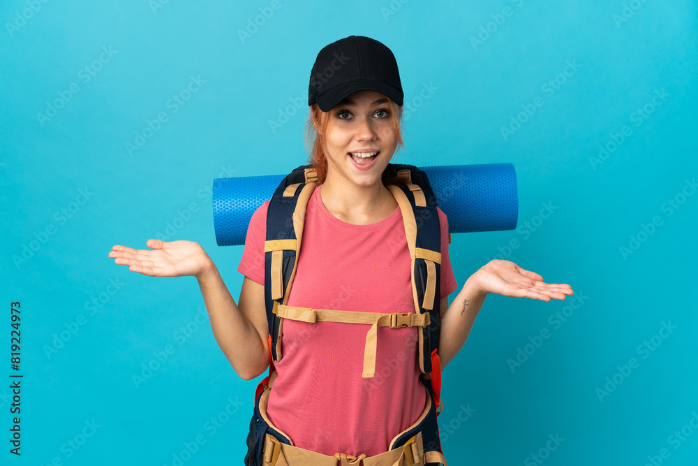 Teenager Russian hiker girl isolated on blue background with shocked facial expression Teenager Russian hiker girl isolated on blue background with shocked facial expression
